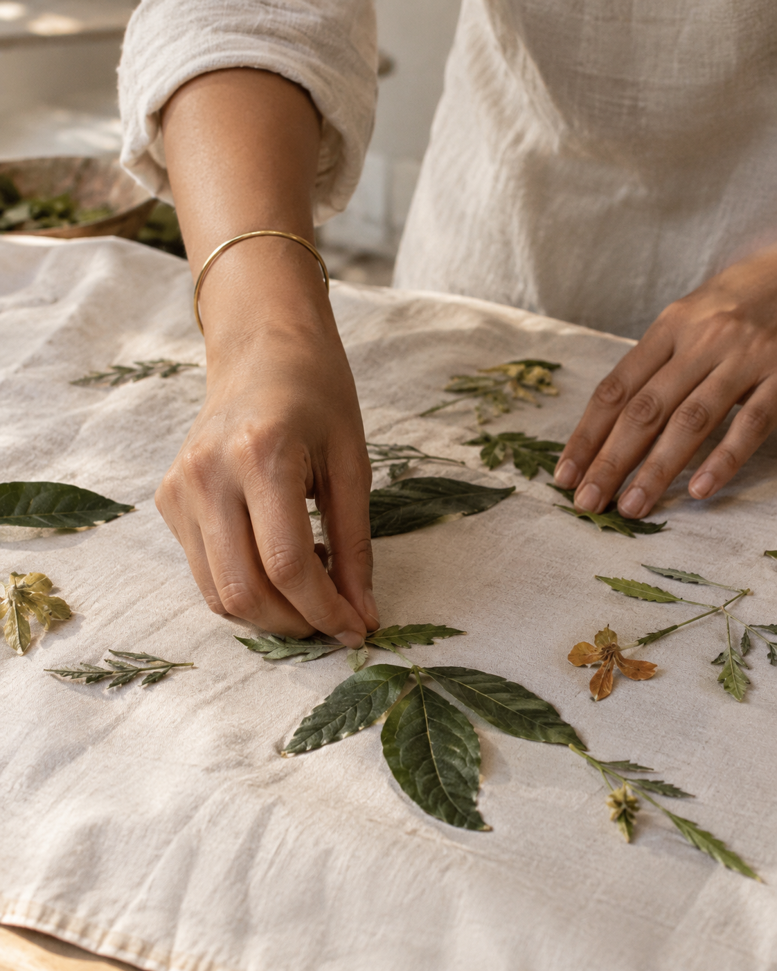 Leaves being arranged by hand on fabric